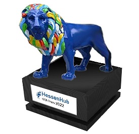 Der Preis ist ein blauer Löwe mit bunter Mähne auf einem Sockel.
